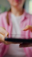 Woman scrolling through social media feeds on smartphone close up, touching touchscreen, using messenger application. Vertical video