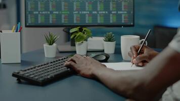 hombre trabajando en computadora y escritura notas en oficina. video
