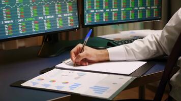 comerciante analisando estoque mercado dados em múltiplo computador telas. video