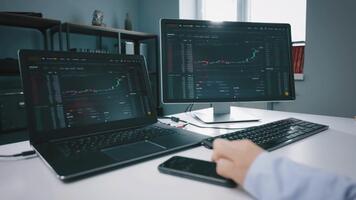 professionell näringsidkare analyserar stock marknadsföra data på flera olika skärmar i en modern kontor miljö. video
