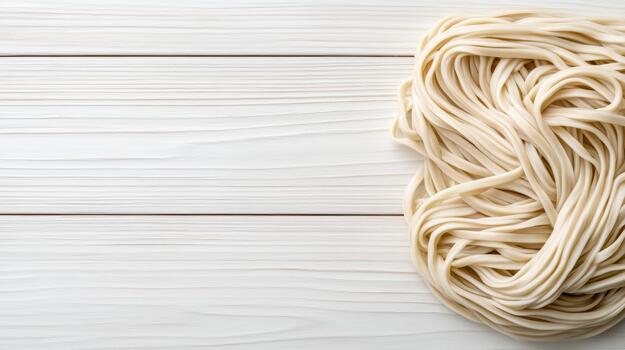Fresh raw udon noodle nest on white wooden board, soft texture and minimal mood photo