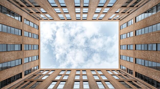Rectangular courtyard sky framed by brick office building with reflective windows, airy mood photo