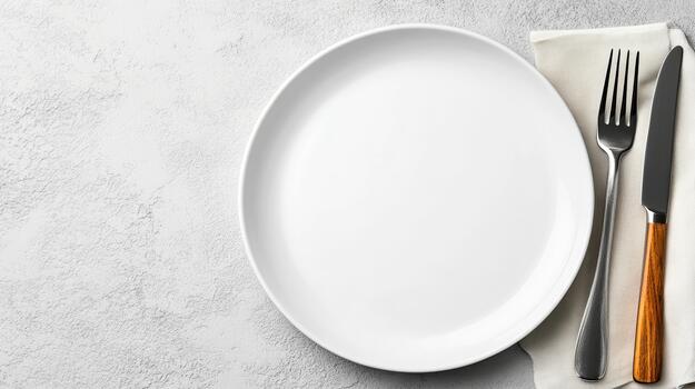 Empty white ceramic plate with fork and knife on napkin, minimal tableware and textured surface photo