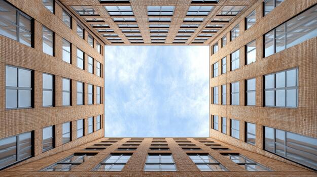 Open sky framed by tall brick building courtyard, symmetrical perspective with soft light photo