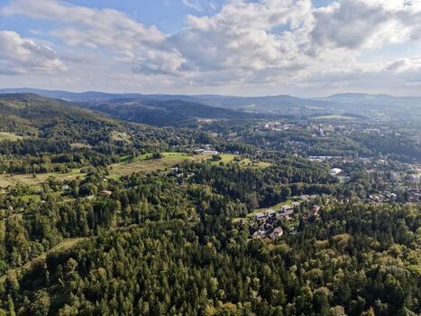Scene Depicting Natural Greenery Transitioning Into Urban Development Beneath Layered Cloud Formations photo