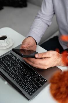 manos utilizando un teléfono inteligente y ordenador portátil durante un negocio reunión. moderno flujo de trabajo, trabajo en equipo y digital comunicación en oficina ambiente. foto