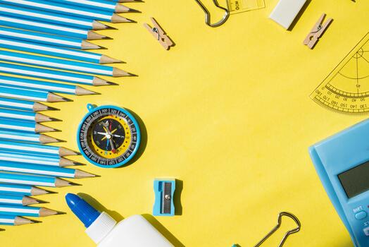 Minimal creative background with stationery objects on edges and empty yellow space in center for text. Perfect for education and advertising designs. photo