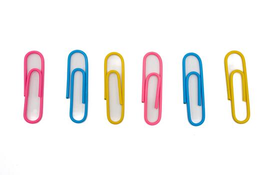 Bright multicolor paper clips arranged in a neat row on a white background. Clean minimal design suitable for office, school, business, and productivity concepts. photo
