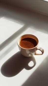 Mañana café taza descansando en un iluminado por el sol mesa, fundición un suave sombra en un acogedor interior ajuste foto
