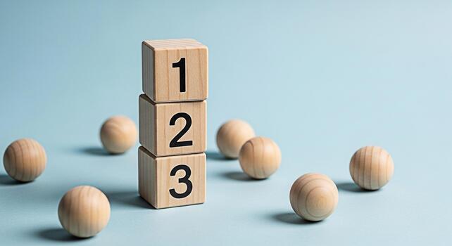 Stacked wooden blocks displaying numbers 1 2 3 surrounded by smooth wooden balls on a clean light blue background representing sequential steps priority and organized processes photo