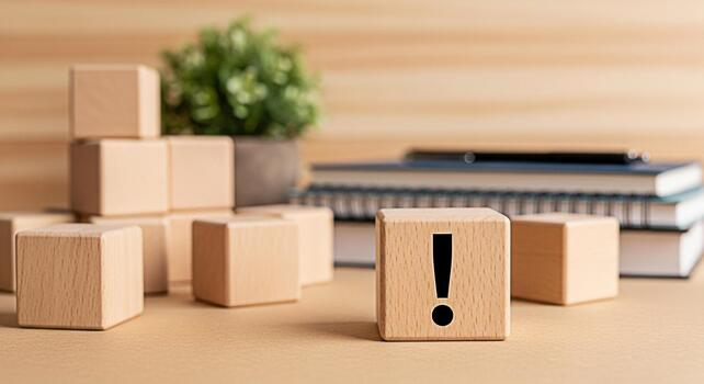 Wooden block displaying an exclamation mark on a desk with books and a plant pot symbolizing attention caution and the importance of problemsolving in a learning or office environment photo