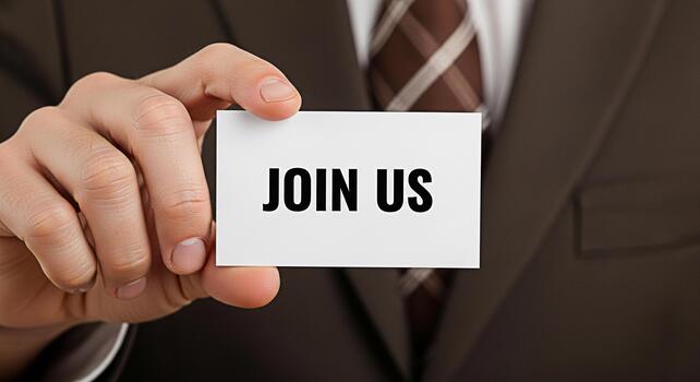 Professional businessman in a suit holding a card with the words Join Us in a corporate setting inviting new members and creating a sense of opportunity and growth symbolizing recruitment and teamwork photo