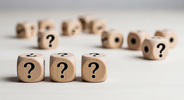 Wooden dice displaying question marks on a white surface representing uncertainty and the need for answers in a business or personal context creating a mood of curiosity and problemsolving photo
