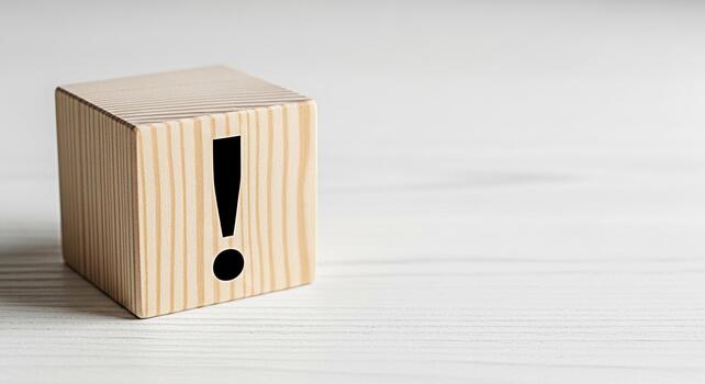 Wooden block displaying an exclamation point on a white wooden surface symbolizing urgency and attention to detail in a clean minimalist setting conveying a sense of importance and caution photo