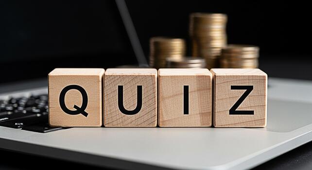 Wooden blocks spelling QUIZ resting on a laptop keyboard with blurred golden coins in the background symbolizing online knowledge assessment educational challenges and potential re photo