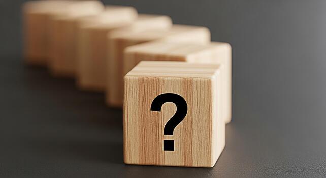 Wooden blocks with a question mark in a row on a dark background representing questions an photo