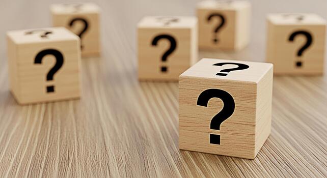 Wooden cubes displaying question marks on a wooden surface symbolizing uncertainty and the need for answers in a business or educational context creating a thoughtful and inquisitive mood photo