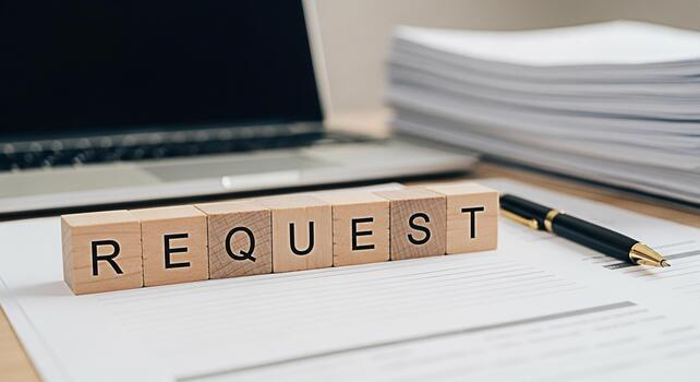 Wooden blocks spelling REQUEST on a desk with laptop and paperwork symbolizing business inquiries and information requests in a professional office setting creating a mood of formality and anticipatio photo