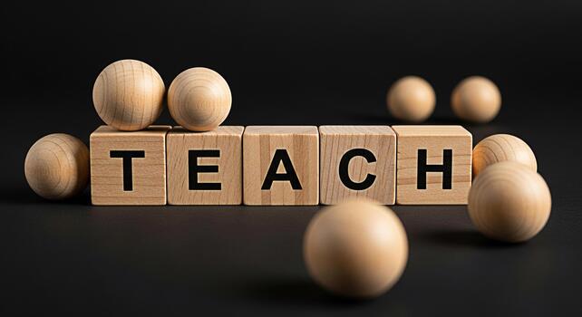 Wooden blocks spelling TEACH surrounded by wooden balls on a dark surface symbolizing education learning and the importance of teaching in a simple minimalist setting photo