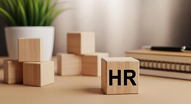 Wooden HR blocks standing on a desk in a bright office representing human resources management and the importance of employees in a company creating a positive and supportive work environment photo