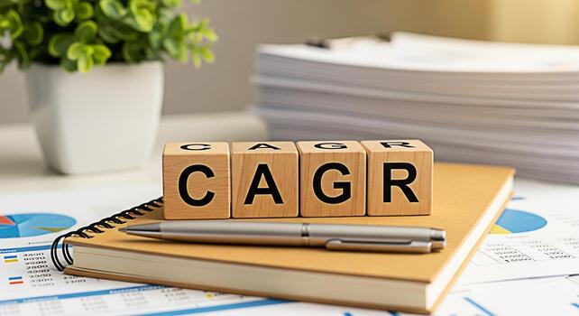 Wooden blocks spelling CAGR resting on a notebook in a bright office setting symbolizing compound annual growth rate and financial success with charts and documents in the background photo