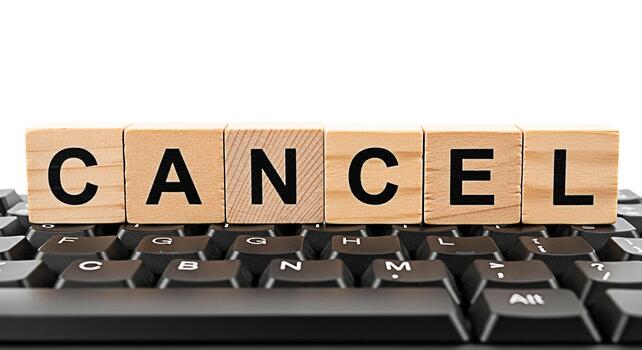 Wooden blocks spelling CANCEL sitting atop a black computer keyboard symbolizing the act of canceling an online subscription or appointment conveying a sense of finality and decisionmaking in a digita photo