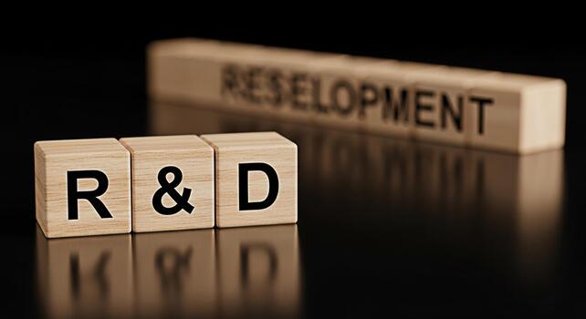 Wooden blocks displaying RD and Redevelopment on a sleek black surface symbolizing innovation and strategic business growth in a corporate environment conveying a sense of progress and investment photo