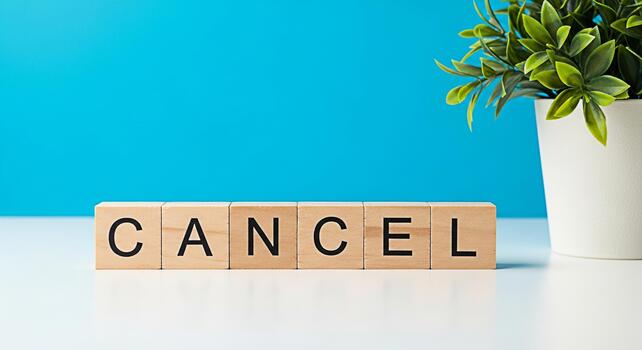 Wooden blocks spelling CANCEL on a white table against a vibrant blue backdrop symbolizing the act of canceling termination and the concept of ending subscriptions or memberships with a sense of final photo