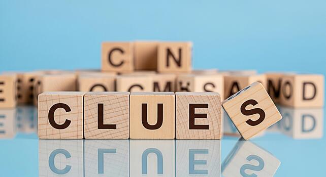 Wooden blocks spelling Clues on a reflective surface against a blue background representing problemsolving and the search for answers in a playful and educational environment fostering curiosity photo