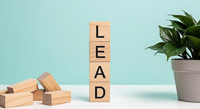 Wooden blocks spelling LEAD standing tall on a white table against a teal background symbolizing leadership guidance and success in a business or personal development context with a plant adding a tou photo