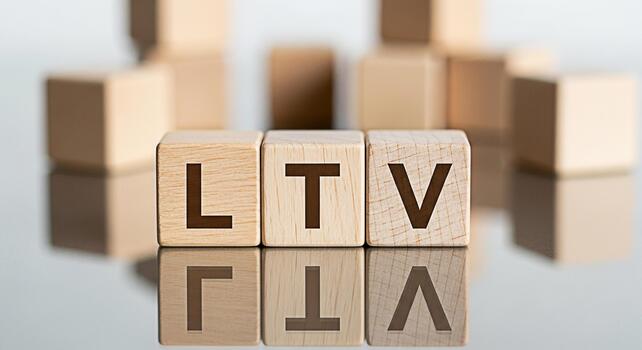 Wooden blocks displaying LTV on a reflective surface representing customer lifetime value in a business setting conveying a message of growth and financial success photo