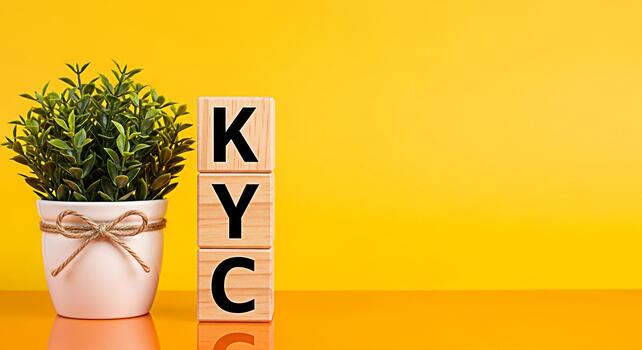 Wooden blocks displaying KYC next to a potted plant on a yellow background representing the concept of compliance and identity verification in a bright and modern setting promoting trust and security photo