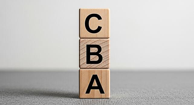 Wooden blocks displaying CBA in a minimalist studio setting representing costbenefit analysis and strategic decisionmaking for business planning and financial assessment with a focus on efficiency photo