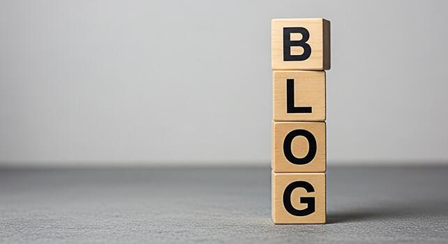 Wooden blocks spelling BLOG stacked vertically on a gray surface symbolizing online content creation and digital marketing strategy in a minimalist studio setting conveying a modern and informative co photo