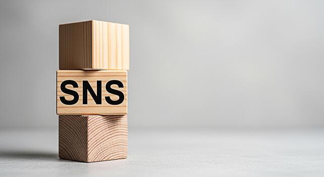 Stack of wooden blocks displaying SNS in a minimalist studio setting symbolizing social networking services and online communication platforms with a focus on connection and information sharing photo