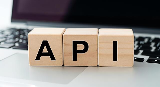 Wooden blocks displaying API on a laptop keyboard symbolizing application programming interface development and integration in a modern tech environment representing connectivity and innovation photo