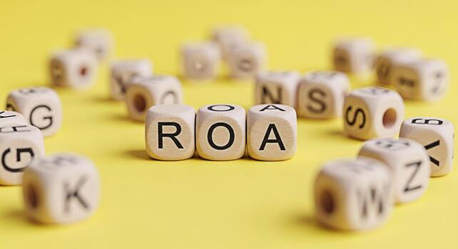 Wooden alphabet blocks spelling ROA on a bright yellow background representing Return on Assets financial performance and investment success in a simple and visually engaging way photo
