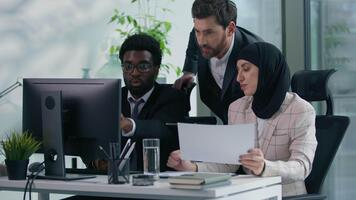 multicultureel bedrijf collega's samenspel in kantoor multiraciaal drie collega's werken samen verscheidenheid partners pratend analyseren gegevens in computer en papieren documenten vergadering brainstorming video