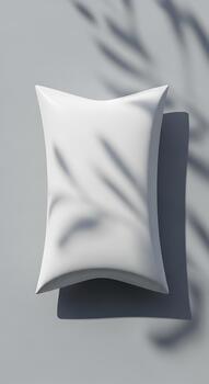 un limpiar blanco almohada fundición un suave sombra en un ligero gris superficie con sutil hoja patrones foto