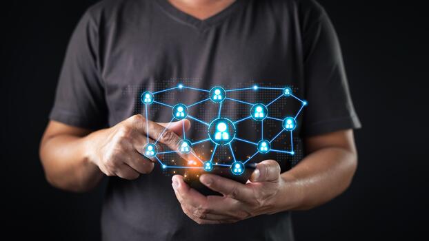 A person interacts with a smartphone, displaying a glowing digital network of connected user icons symbolizing social network connectivity, communication, and global online interaction via technology. photo