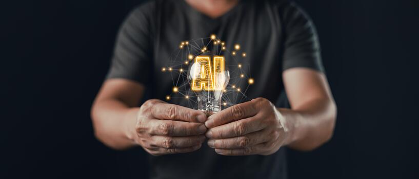 A person holds a glowing lightbulb with digital connections and the text AI inside, symbolizing idea, innovation, and creative technology powered by artificial intelligence and neural networks. photo