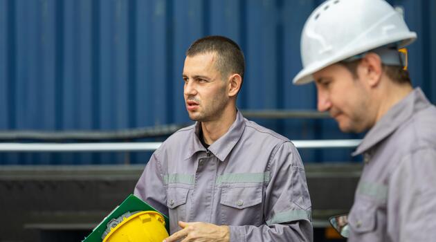 Industrial Engineers Discussing Work Details at Cargo Container Terminal, Portrait of Male Foreman Talking to Colleague with Shipping Container Background photo