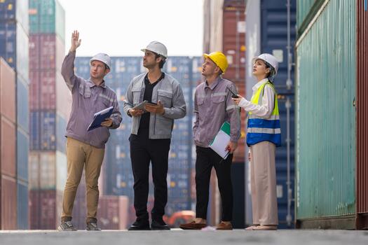 Engineers and dock workers inspecting cargo containers at shipping yard, Industrial team coordinating freight logistics at container terminal, Team reviewing operations and safety at port photo