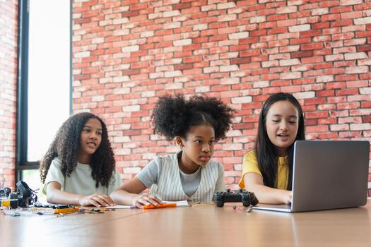 Diverse Young Girls Working Together on Programming and STEM Project, Multicultural Students Learning Coding and Robotics on Laptop in Class, Group of Children Collaborating on a School Project photo
