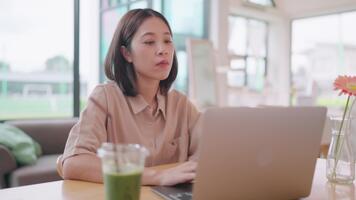 Freelance worker sitting alone in cafe using laptop with worried expression about project failure and data loss symbolizing remote work stress and digital job uncertainty. video