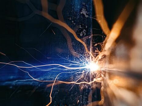 Close-up view of an electric welding arc showing bright sparks and intense energy during a metal fabrication process in a workshop photo
