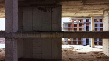 utforska de övergiven strukturera av en halvfärdig byggnad under en ljus himmel, avslöjande unik arkitektonisk element och tips av natur återta Plats video