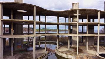 utforska en glömt betong strukturera förbi de vatten på en molnig dag i en avlägsen plats video