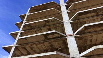 betong strukturera når för de himmel med tömma utrymmen avslöjande rå kraft i en djärv, oavslutat design under en ljus blå himmel video