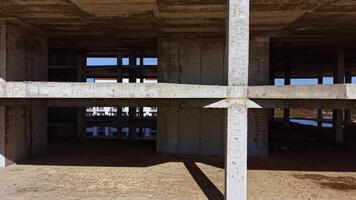 konstruktion webbplats som visar betong strukturera med balkar och skuggor under en ljus himmel, reflekterande de framsteg av urban utveckling och arkitektonisk design video